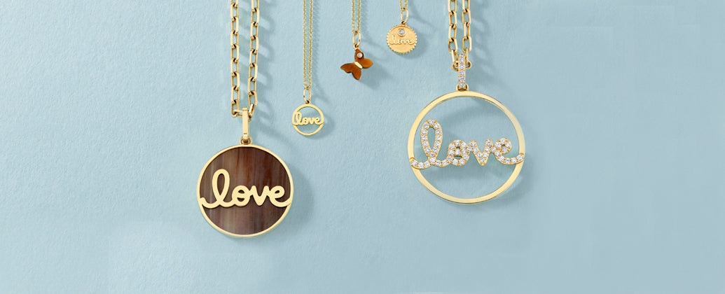 Gold necklaces with Love pendants displayed against a blue background